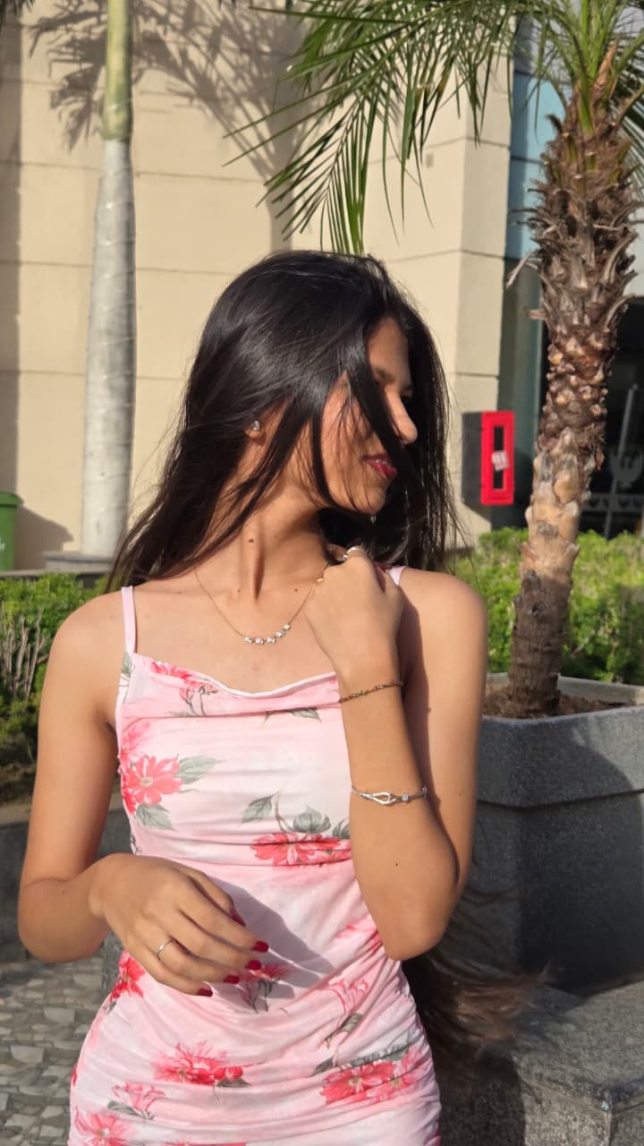 Close portrait of Bhakti in a pink floral dress with her hair blowing across her face
