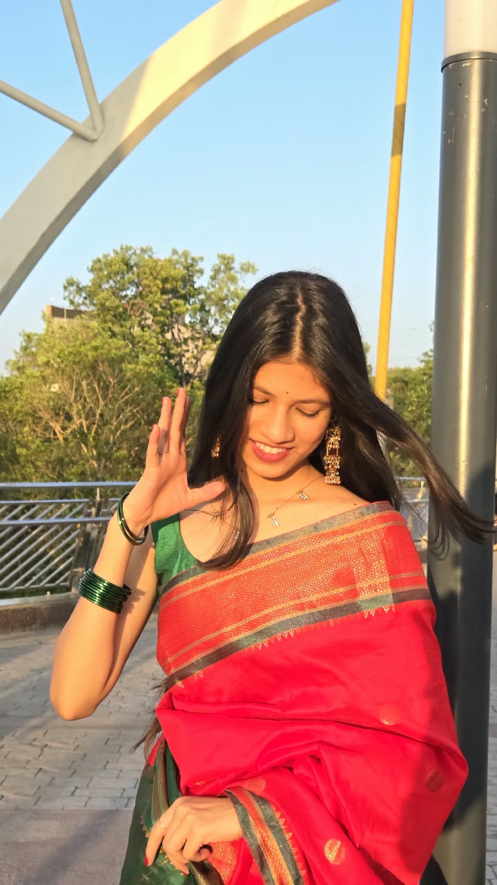 Bhakti in a red saree with her hair in motion, mid-gesture